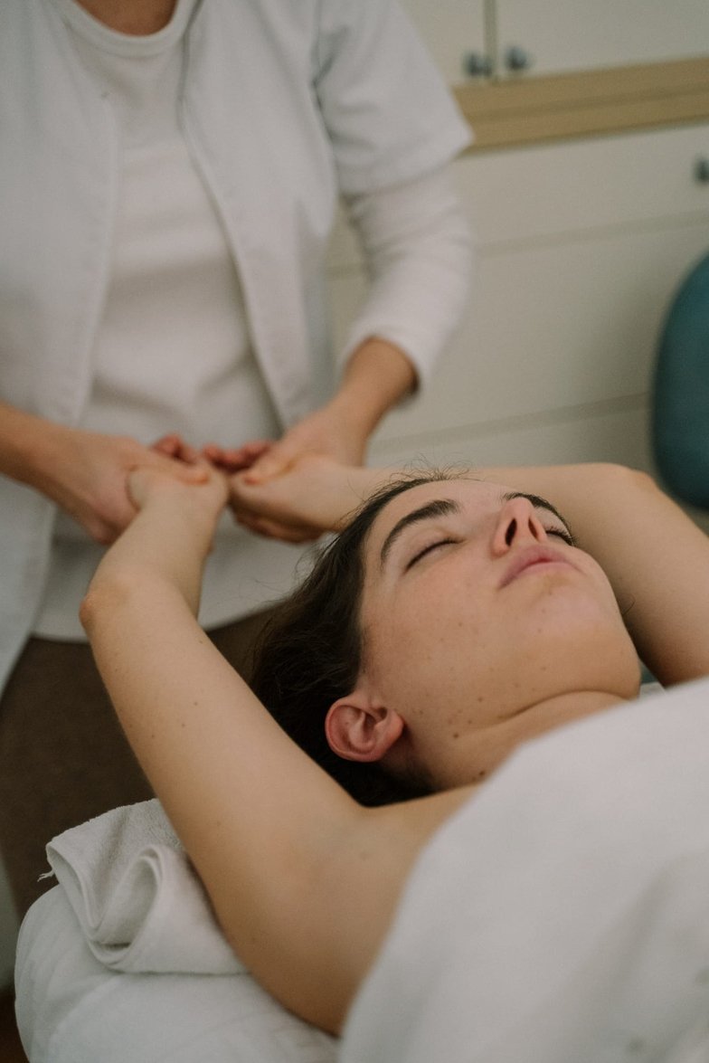 Terapeuta realizando masaje de manos a mujer